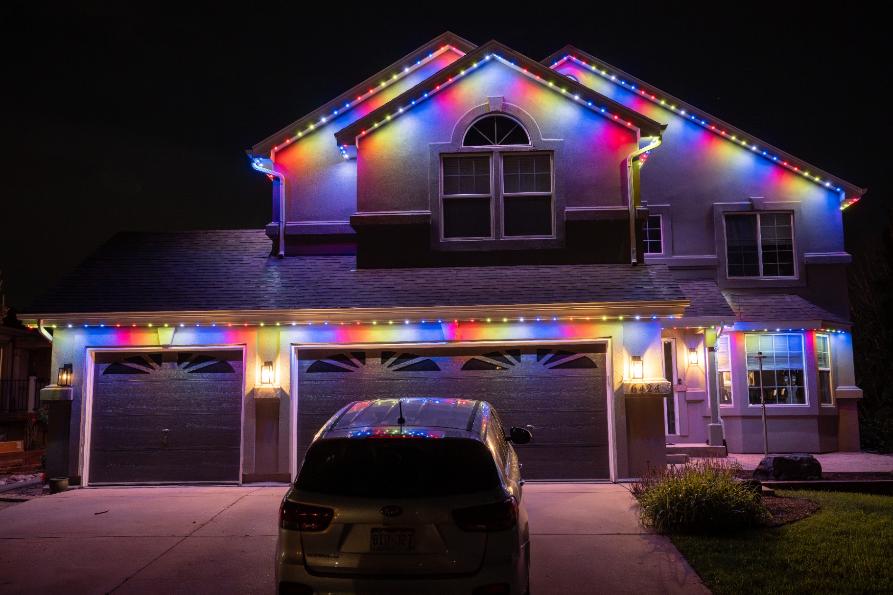 Multicolor lighting on a two-story home with three-car garage