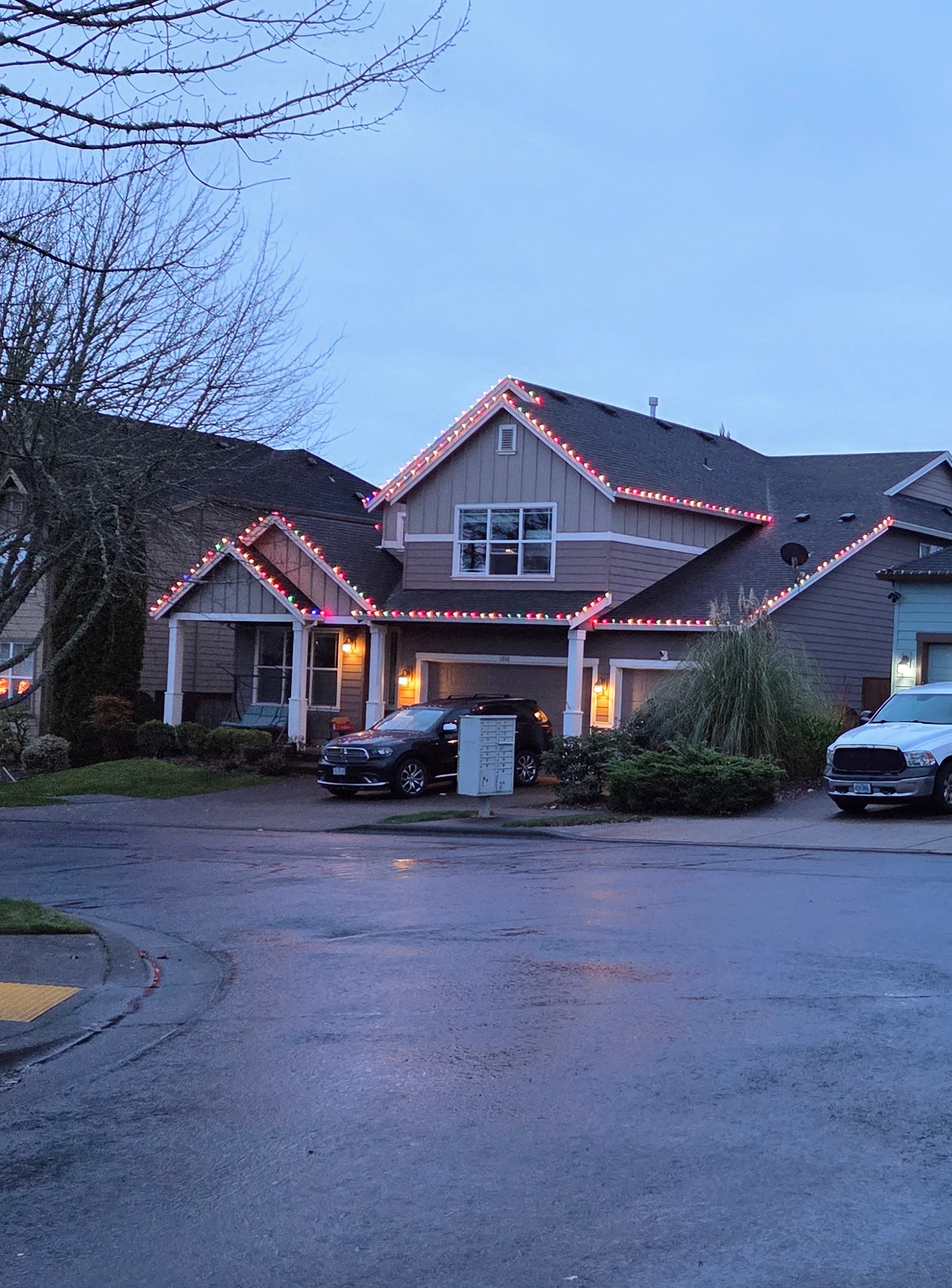 Red and white Christmas roofline lighting at dusk