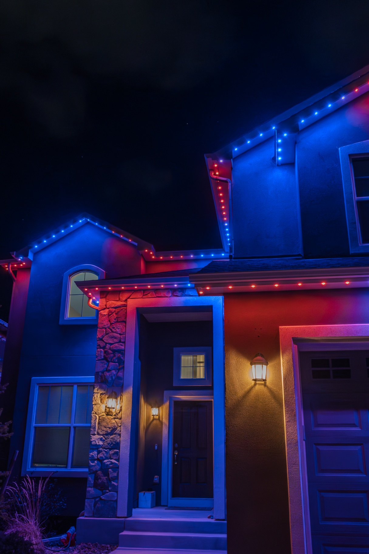 Red and blue lighting illuminating a home entry and garage