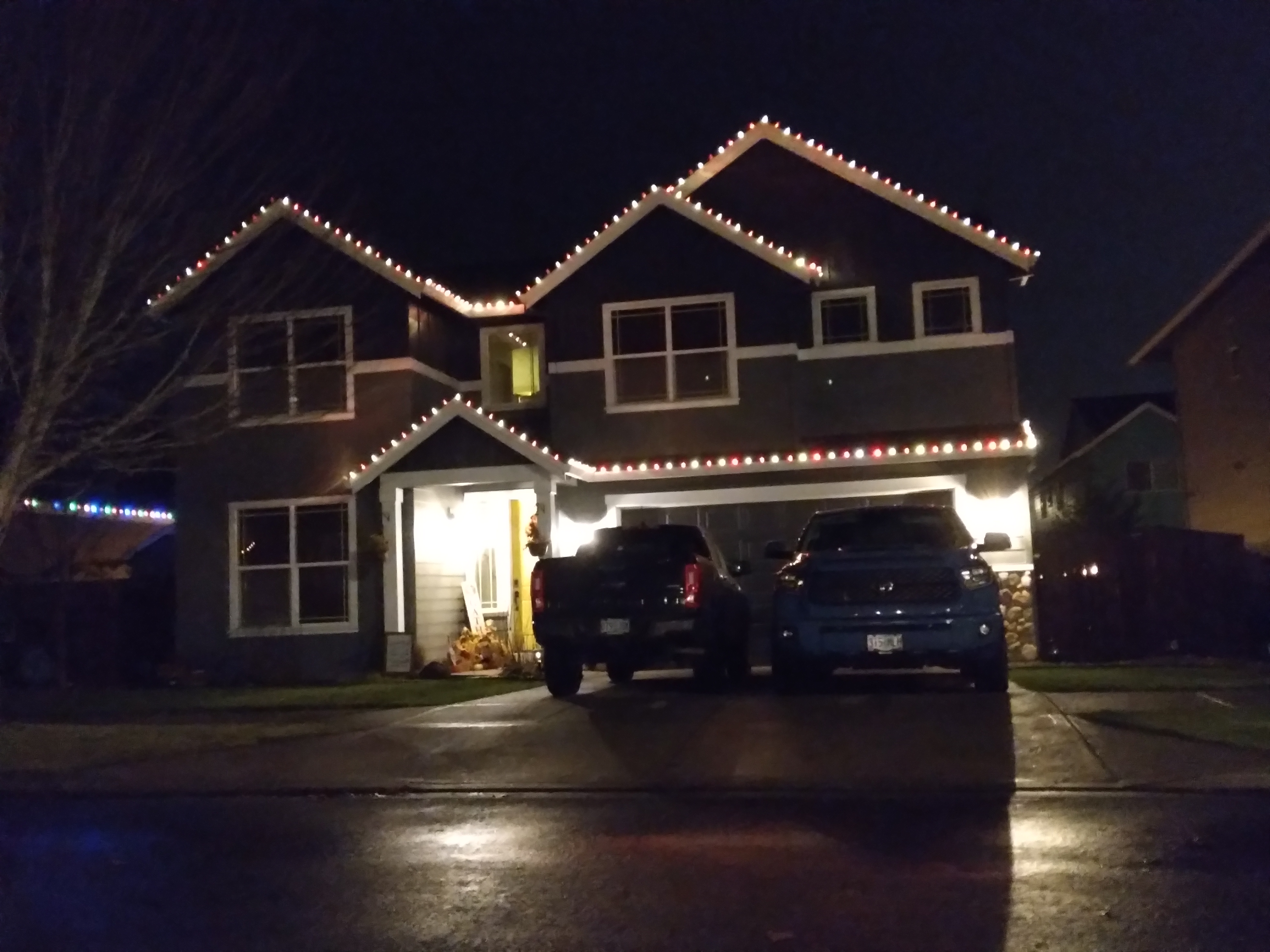 Warm white Christmas roofline lighting on a home at night
