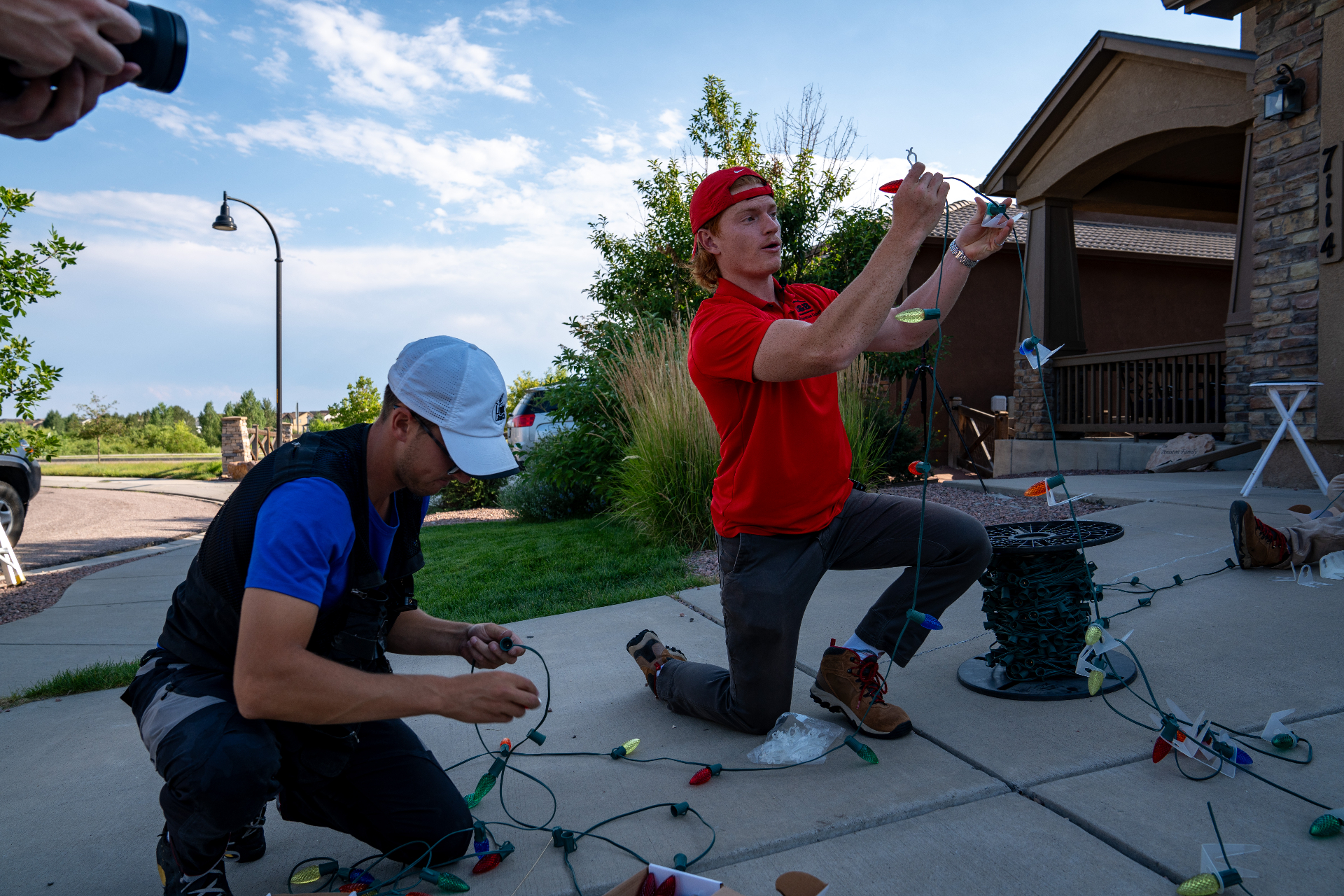 Got Lights LLC installer hanging Christmas lights on a roofline